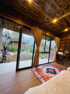 1 dormitorio con 1 cama y grandes ventanas de cristal en Anh Duc Homestay, en Sa Pa