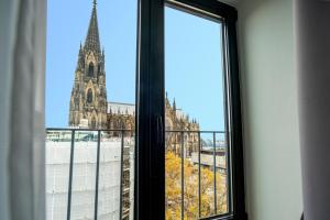 une fenêtre avec vue sur une église dans l'établissement Eden Hotel Früh am Dom, à Cologne