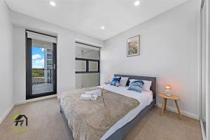 a bedroom with a large bed and a window at Entire 3 Bedroom in Bankstown in Bankstown