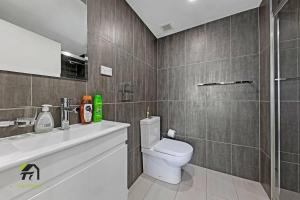 a bathroom with a toilet and a sink and a shower at Entire 3 Bedroom in Bankstown in Bankstown
