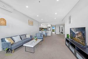 a living room with a couch and a tv at Entire 3 Bedroom in Bankstown in Bankstown