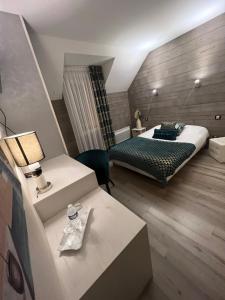 - une chambre d'hôtel avec un lit et une table avec un sidx dans l'établissement Hôtel Bien Être La Glycine, à Bénouville