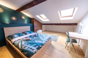 um quarto com uma cama, uma mesa e janelas em Kasa Java - Très spacieux, tout équipé et confortable - Proche centre em Saint-Étienne
