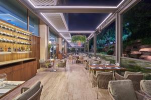 ein Restaurant mit Tischen, Stühlen und Fenstern in der Unterkunft DoubleTree by Hilton Hotel Istanbul - Tuzla in Istanbul