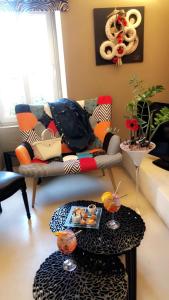 a living room with a couch and a table at Hôtel La Glycine in Bénouville