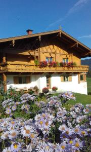 a house with flowers in front of it at Ferienwohnungen Fahringer Diana in Kössen