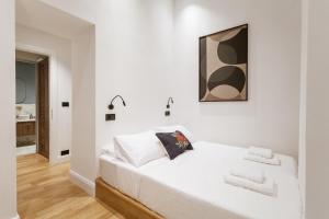een witte slaapkamer met een wit bed met 2 kussens bij Zerania Suites in Rhodos-stad