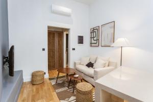 een witte woonkamer met een bank en een tafel bij Zerania Suites in Rhodos-stad