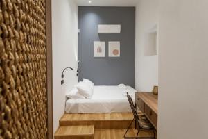 een slaapkamer met een wit bed en een bureau bij Zerania Suites in Rhodos-stad