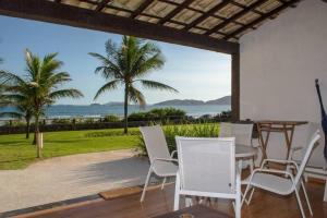 a patio with a table and chairs and a view of the ocean at Casa Frente para o Mar em Búzios, Geribá Beach! in Búzios