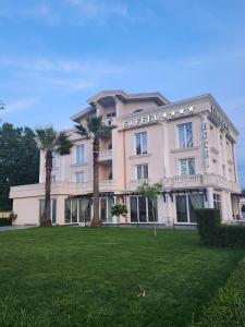 ein großes Gebäude mit Palmen davor in der Unterkunft Hotel Eiffel in Tirana + 37 Fotos