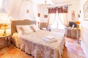 una camera da letto con un letto, un tavolo e una finestra di Mas de l'Olivette a Cotignac