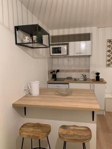 a kitchen with a wooden counter and two stools at Mazet T2 - Domaine de la Pinède - Piscine Chauffée in Le Lavandou