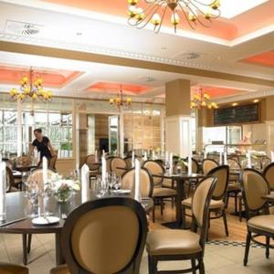 a restaurant with tables and chairs and a person in the background at West Cork Hotel in Skibbereen