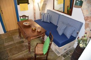莫奈姆瓦夏的住宿－Blue Door (in the castle of Monembasia)，小房间设有桌子和蓝色的沙发