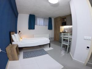 a small room with a bed and a kitchen at Apart-hotel TARHUN in Tbilisi City
