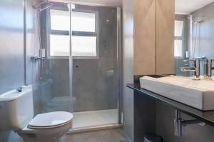a bathroom with a shower and a toilet and a sink at Hotel Lauria in Tarragona