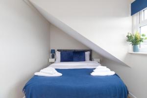 a bedroom with a blue bed with towels on it at Cosy Apartment Coventry City Centre in Coventry