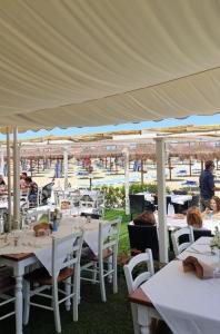 een restaurant met witte tafels en stoelen onder een tent bij Maison Lulu- Appartamento nuovo in Pescara