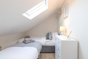 two beds in a attic bedroom with a window at Cosy Apartment Coventry City Centre in Coventry