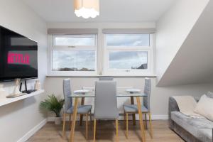 a dining room with a table and chairs and a couch at Cosy Apartment Coventry City Centre in Coventry