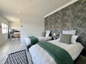 um quarto de hotel com duas camas e uma secretária em On the Main em Walvis Bay