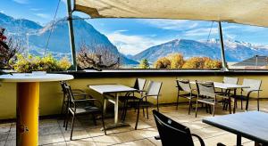 a restaurant with tables and chairs and a view of mountains at TirolerHof Dölsach in Lienz