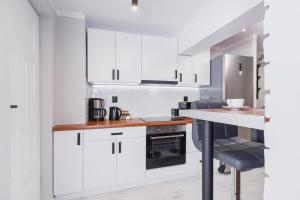 a kitchen with white cabinets and a counter top at STU Theater Underground Apartment Syrokomli by Renters in Krakow