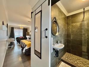 een badkamer met een wastafel en een bed in een kamer bij Jirah@Riverside in Centurion
