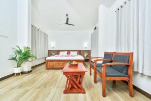a bedroom with a bed and a table and chairs at Clouds View Nature Resort in Koroth