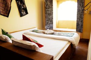 2 Betten in einem Zimmer mit Fenster in der Unterkunft Urmila Homestay in Jaisalmer