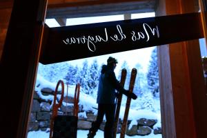 człowiek przechodzi przez drzwi z nartami w obiekcie B&B Mas de Lagorae w mieście Tesero
