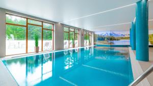 uma grande piscina com água azul numa casa em Apartamenty Good Time - Stone Hill III em Szklarska Poręba