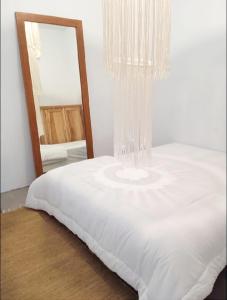- une chambre avec un lit blanc et un miroir dans l'établissement 3Bedrooms Dorf House Gunung Mas, à Kerobokan