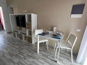 uma sala de jantar com mesa e cadeiras e uma televisão em Paradise Resort - FKK Swinger & Nudist Couples Only em Maspalomas