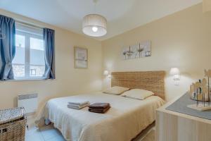 a bedroom with a bed with towels on it at Les Ebihens in Saint-Benoît-des-Ondes