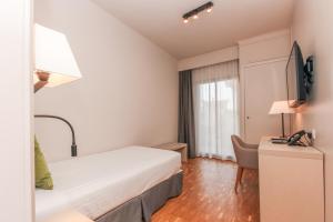 a hotel room with a bed and a desk at Hotel Lauria in Tarragona