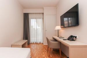 a hotel room with a desk and a phone at Hotel Lauria in Tarragona