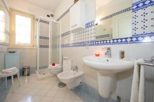 biała łazienka z umywalką i toaletą w obiekcie Casa Emma with Pool - Happy Rentals w Sirmione