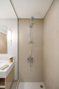 uma casa de banho branca com um chuveiro e um lavatório. em Luxury Dubai Creek Balcony & View em Dubai