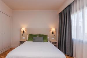 a bedroom with a large white bed and a window at Hotel Lauria in Tarragona