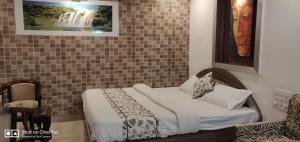 1 dormitorio con cama y pared de azulejos en The Peach Tree Rooms, en Mount Abu