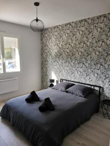 a bedroom with a large bed with a stone wall at La Maison du Bagas, 7pers in Vielmur-sur-Agout