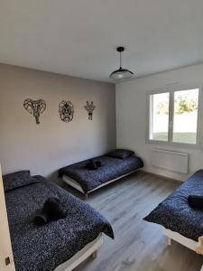 a room with two beds and a window at La Maison du Bagas, 7pers in Vielmur-sur-Agout