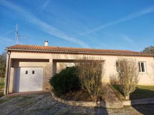 a small house with a garage and a driveway at La Maison du Bagas, 7pers in Vielmur