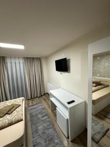 a hotel room with a bed and a desk with a tv at Conacul Peștera Urșilor in Chişcău