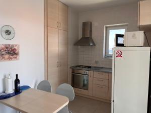 a kitchen with a refrigerator and a table with chairs at Apartments Paska Preko in Preko