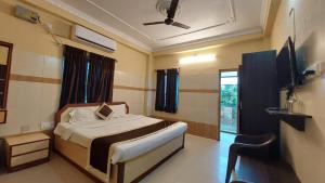 a bedroom with a bed and a tv in it at Goroomgo Star Inn Puri in Puri