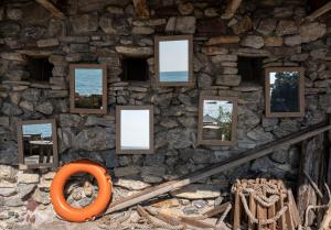 a wall with pictures on a stone wall at Eco del Mare in Lerici