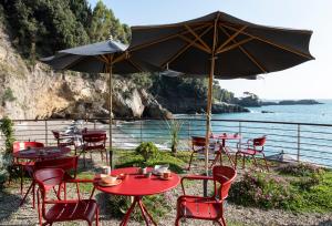 a group of tables and chairs with an umbrella at Eco del Mare in Lerici
